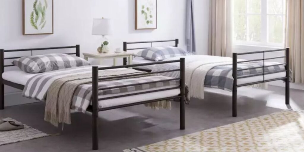 Two twin beds with blankets and pillows in a room.