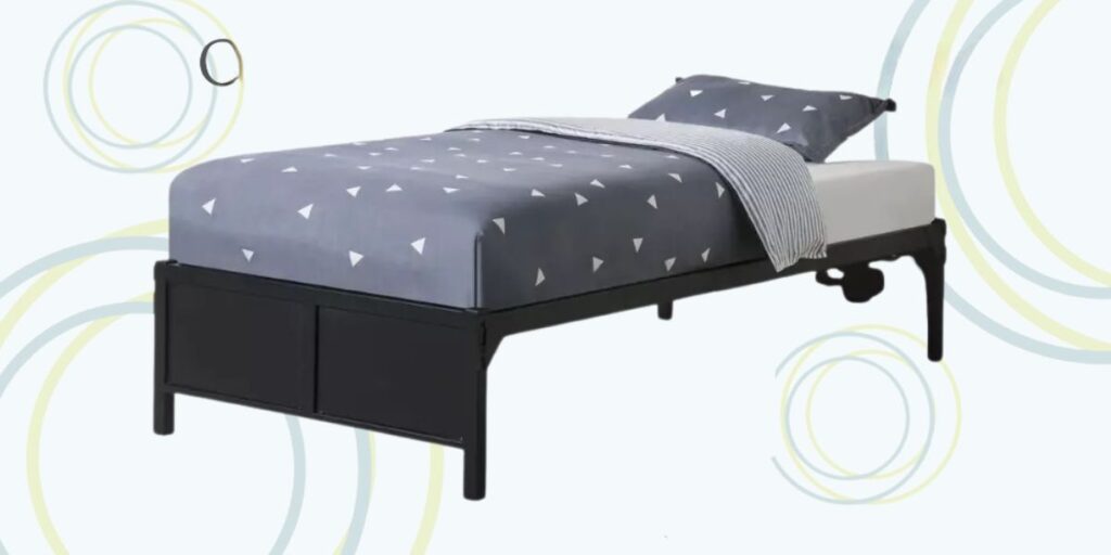 A sturdy metal platform bed with a gray and white bedspread, perfect for shelters needing durable sleeping solutions.