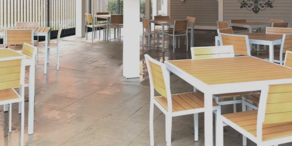 A restaurant featuring tables and chairs positioned in front of a sliding glass door, emphasizing a welcoming atmosphere.