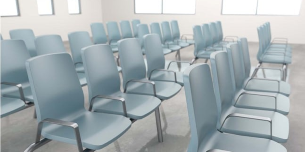 A row of plastic chairs arranged neatly in an empty room, highlighting a minimalist and functional design.