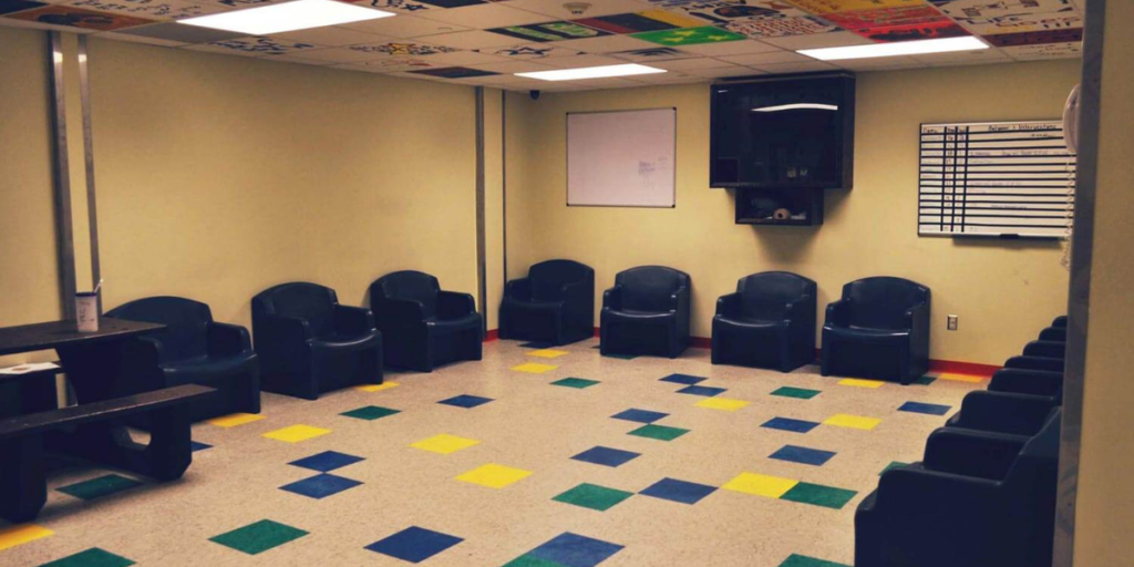 A waiting room featuring durable plastic chairs and a table, designed for functionality and comfort in healthcare settings.