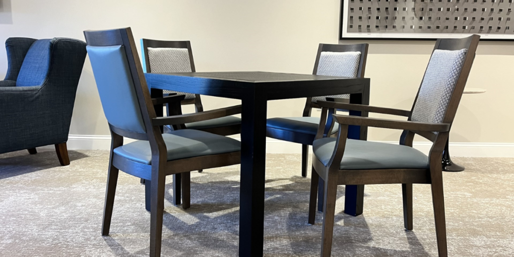 A dining table with four chairs, promoting independence and confidence in daily tasks and enhancing well-being.