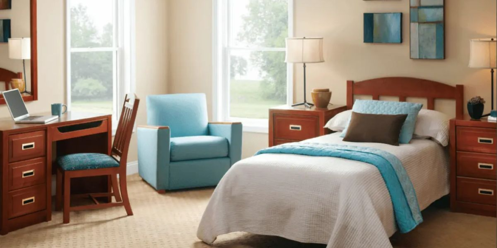 A cozy bedroom featuring a bed, desk, and chair, designed for comfort and accessibility with personal touches.