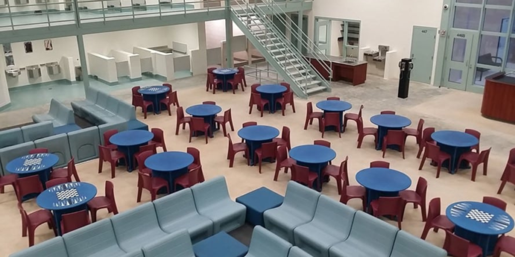 A spacious room featuring tables and chairs, designed for social interaction and community activities among residents.