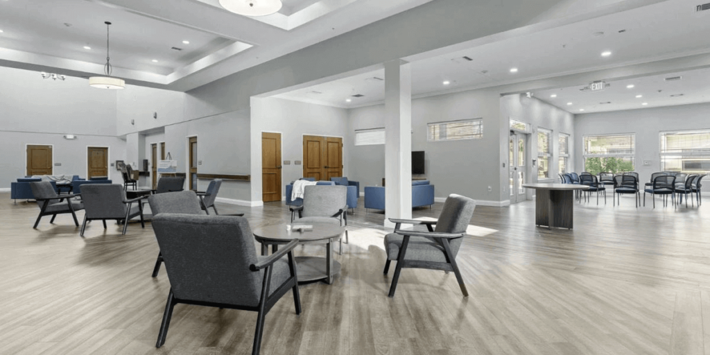 A welcoming dining room in a senior living community, featuring steel-framed chairs designed for durability and low maintenance.