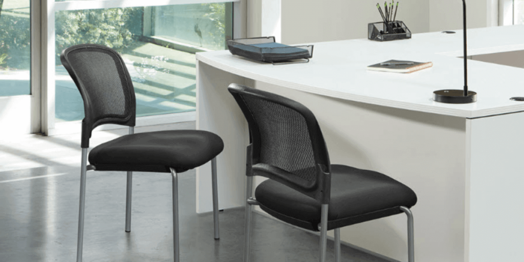 Two black chairs positioned in front of a desk, showcasing a functional and professional seating arrangement.