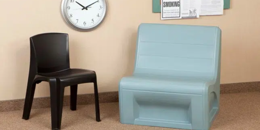 A chair positioned beside a clock in a well-lit room, showcasing a blend of comfort and timekeeping.