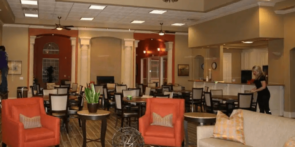 A spacious hotel lobby featuring a large dining area, designed for comfort and social interaction among guests.
