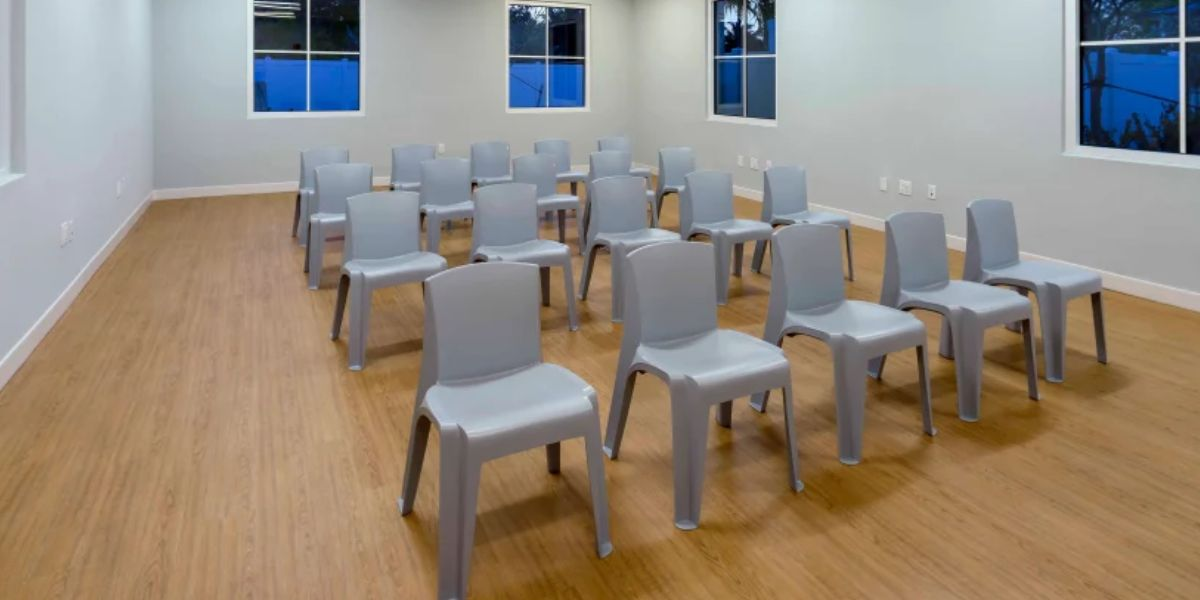 A room featuring adaptable chairs and a table, designed for flexible healthcare use and sustainable practices.