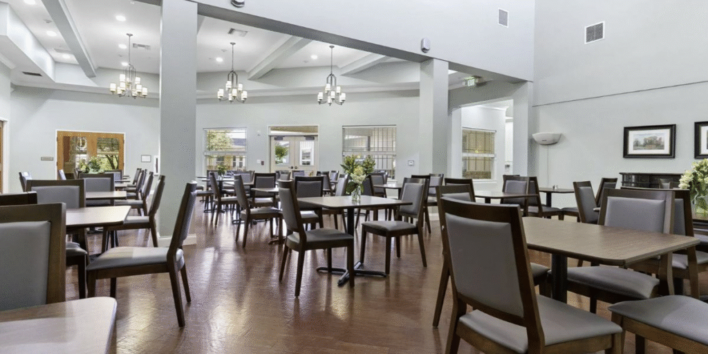Dining room in a senior living community, featuring inviting furniture arranged to create a warm and welcoming atmosphere.